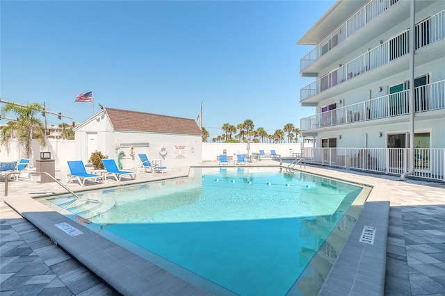 pool with a patio area and fence