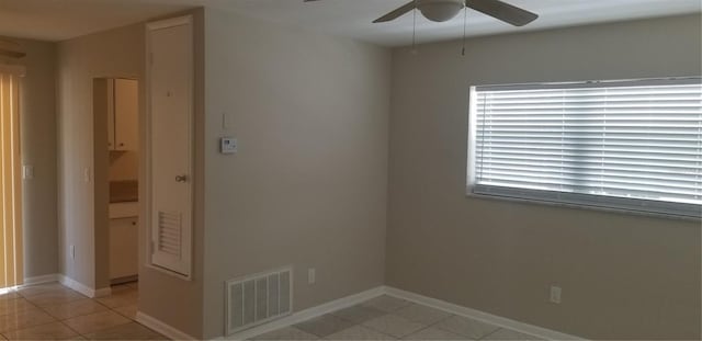 unfurnished room with light tile patterned floors, ceiling fan, baseboards, and visible vents