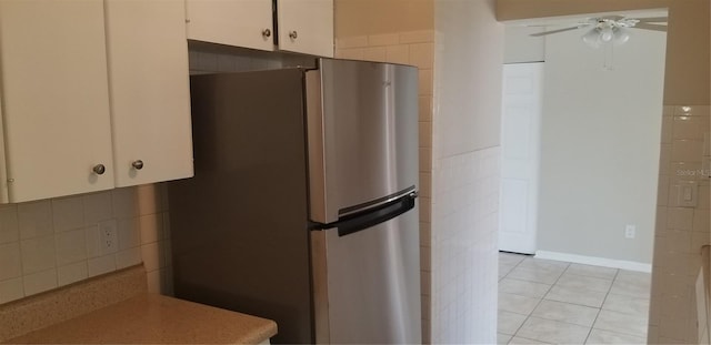 kitchen featuring freestanding refrigerator, light tile patterned floors, ceiling fan, light countertops, and white cabinets