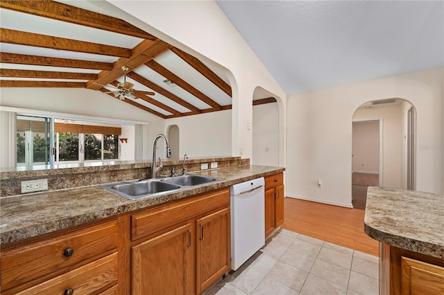 11094 SE 173rd Ln, Summerfield, FL 34491 - kitchen featuring white dishwasher, a sink, lofted ceiling, arched walkways, and brown cabinets