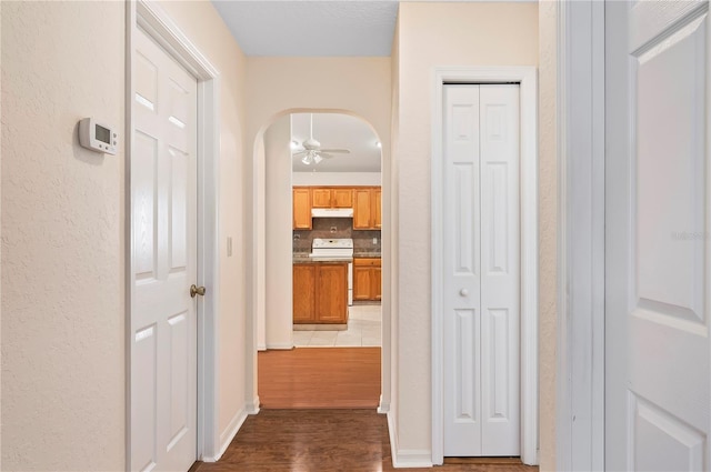 11094 SE 173rd Ln, Summerfield, FL 34491 - hall featuring dark wood-type flooring, arched walkways, and baseboards