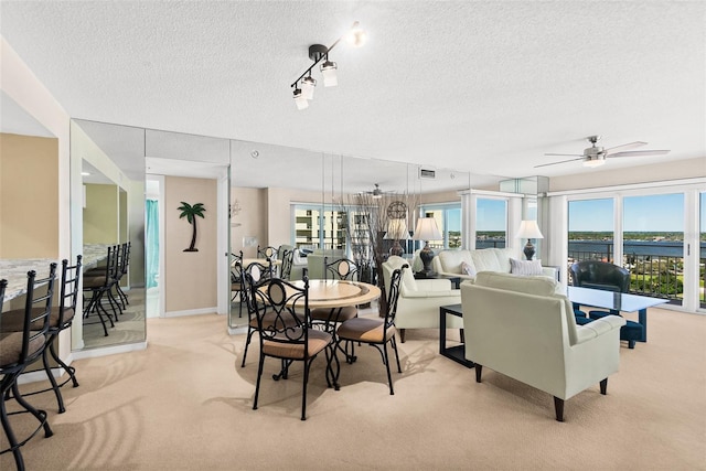 2967 S Atlantic Ave Unit 1601, Daytona Beach Shores, FL 32118 - dining space with a ceiling fan, a textured ceiling, plenty of natural light, and light colored carpet