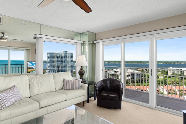 2967 S Atlantic Ave Unit 1601, Daytona Beach Shores, FL 32118 - living area featuring ceiling fan, a textured ceiling, and a water view
