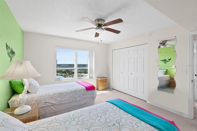 2967 S Atlantic Ave Unit 1601, Daytona Beach Shores, FL 32118 - bedroom featuring a textured ceiling, carpet floors, a closet, and a ceiling fan