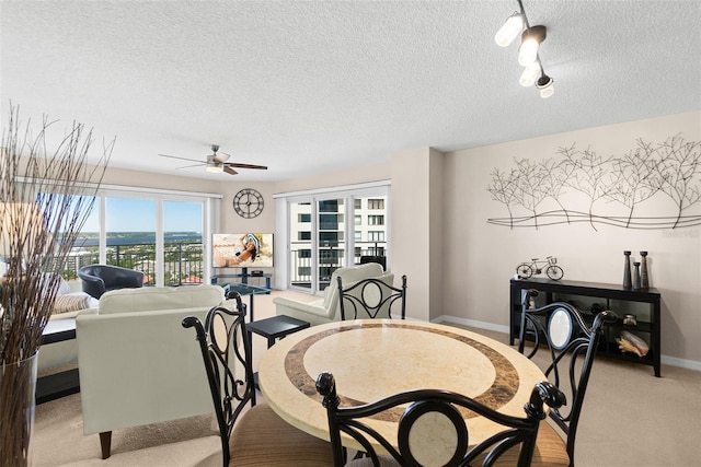 2967 S Atlantic Ave Unit 1601, Daytona Beach Shores, FL 32118 - dining area featuring a textured ceiling, track lighting, light carpet, a ceiling fan, and baseboards