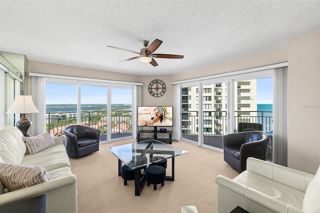 2967 S Atlantic Ave Unit 1601, Daytona Beach Shores, FL 32118 - carpeted living area featuring a ceiling fan, a water view, and a textured ceiling
