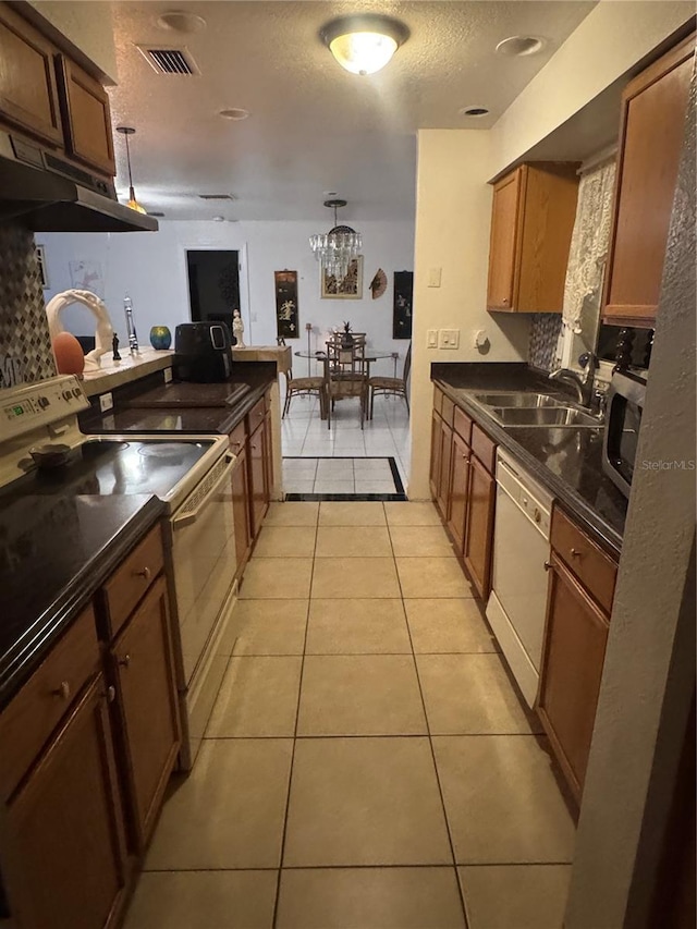 kitchen with white appliances, visible vents, dark countertops, and light tile patterned flooring