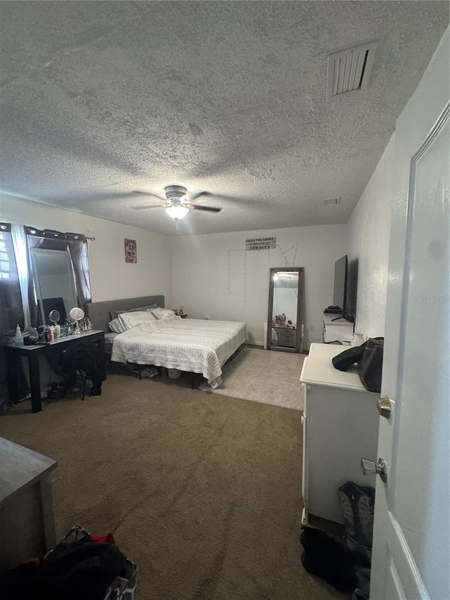 carpeted bedroom featuring a textured ceiling, visible vents, and a ceiling fan