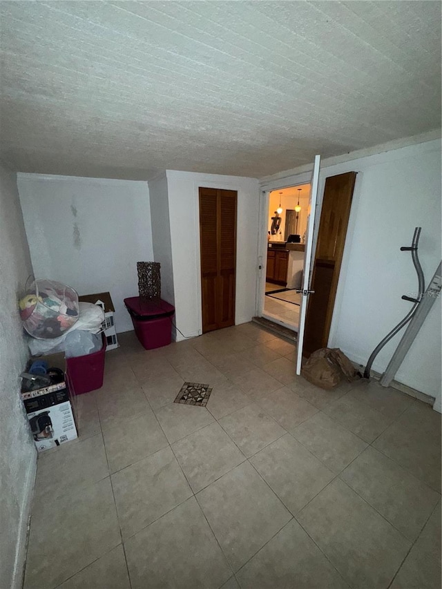 additional living space with a textured ceiling and light tile patterned floors