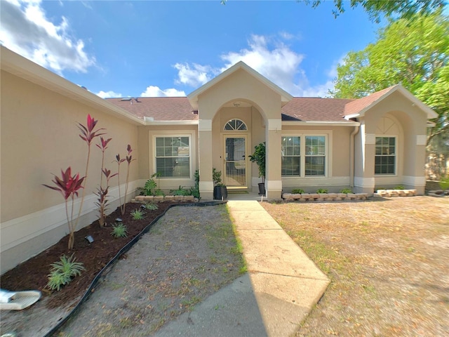 view of front of house with stucco siding and a shingled roof