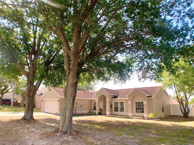 single story home featuring fence, an attached garage, and stucco siding