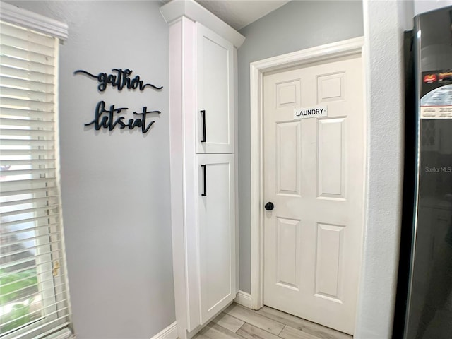 doorway to outside with light wood finished floors and baseboards