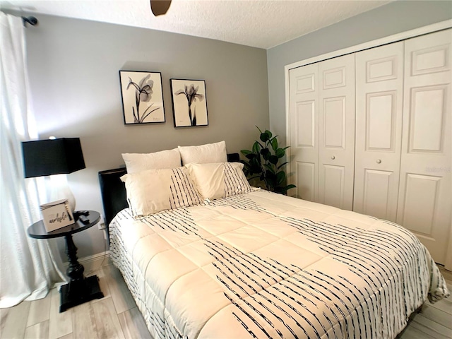 bedroom with a textured ceiling, a closet, and baseboards