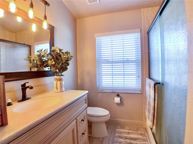full bath with vanity, toilet, a shower stall, and visible vents