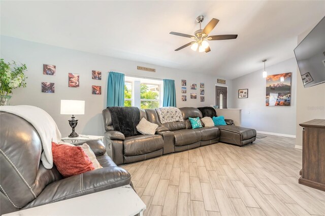 85 Pheasant Dr, Palm Coast, FL 32164 - living room featuring a ceiling fan, vaulted ceiling, light wood-style flooring, and baseboards