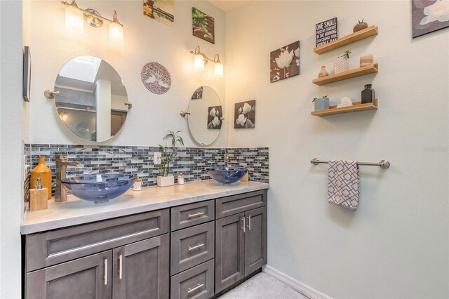 85 Pheasant Dr, Palm Coast, FL 32164 - bathroom featuring backsplash, double vanity, and baseboards
