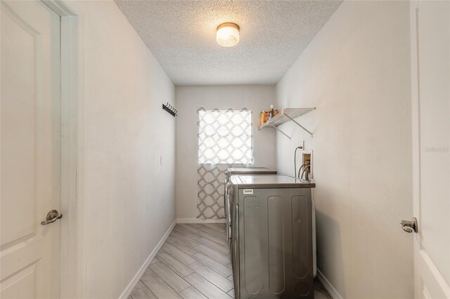 85 Pheasant Dr, Palm Coast, FL 32164 - laundry area with independent washer and dryer, a textured ceiling, baseboards, and light wood-style flooring