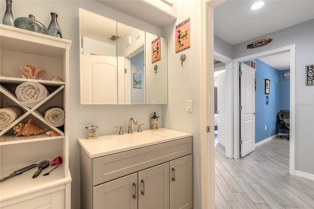 85 Pheasant Dr, Palm Coast, FL 32164 - bathroom featuring vanity, wood finished floors, baseboards, and recessed lighting