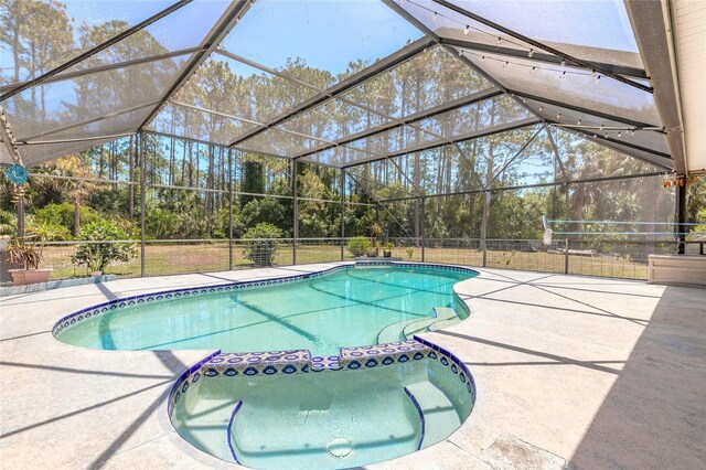 85 Pheasant Dr, Palm Coast, FL 32164 - view of swimming pool featuring a pool with connected hot tub, a patio area, and glass enclosure