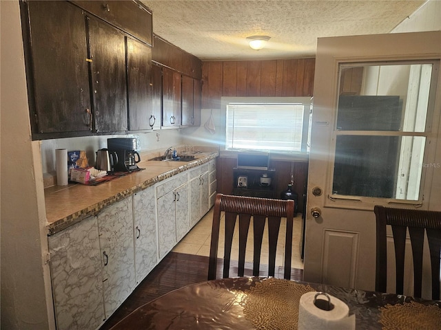 317 Inwood Ave, New Smyrna Beach, FL 32168 - kitchen featuring a textured ceiling, a sink, dark brown cabinetry, and white cabinetry