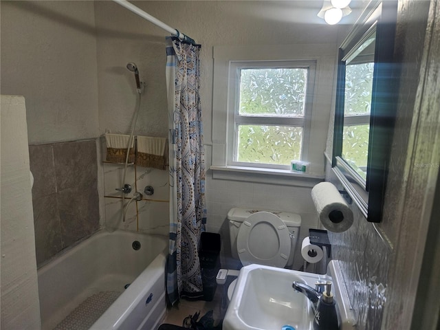 317 Inwood Ave, New Smyrna Beach, FL 32168 - full bath featuring a sink, tile walls, shower / bath combo, toilet, and a wainscoted wall