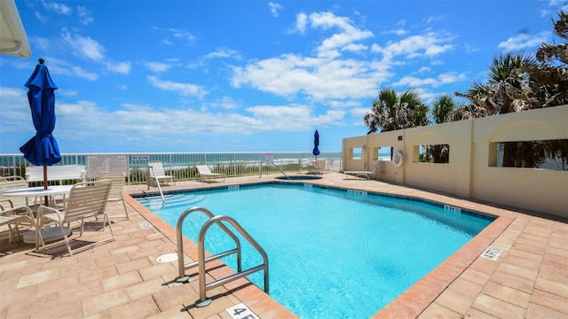 pool featuring a hot tub, fence, and a patio