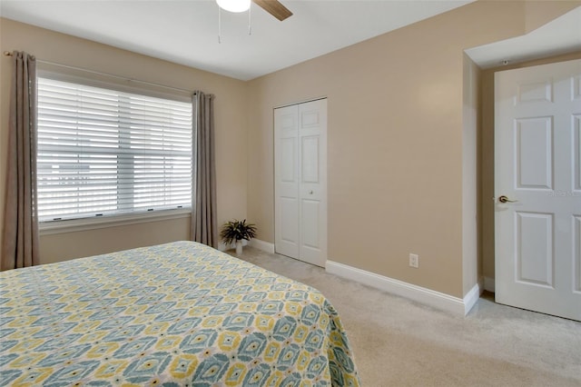 carpeted bedroom featuring ceiling fan, a closet, and baseboards