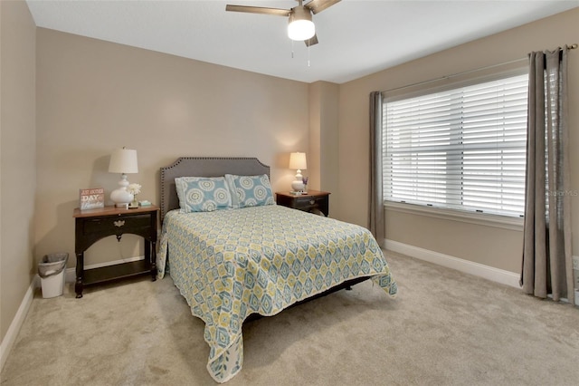 carpeted bedroom with ceiling fan and baseboards