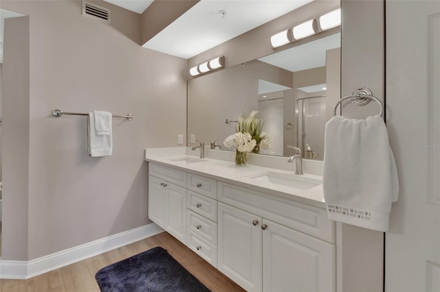 bathroom with visible vents, baseboards, a shower stall, and a sink