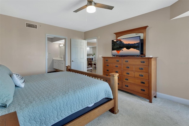 carpeted bedroom with ensuite bath, visible vents, baseboards, and a ceiling fan