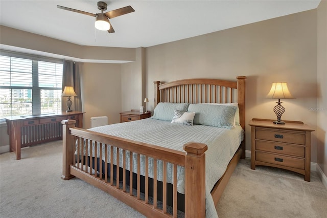 carpeted bedroom with radiator, baseboards, and a ceiling fan