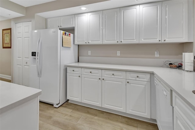 kitchen featuring white cabinetry, white appliances, light countertops, and light wood-style floors