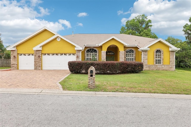2940 SE 23rd Ave, Ocala, FL 34471 - ranch-style home featuring brick siding, a front yard, decorative driveway, and an attached garage