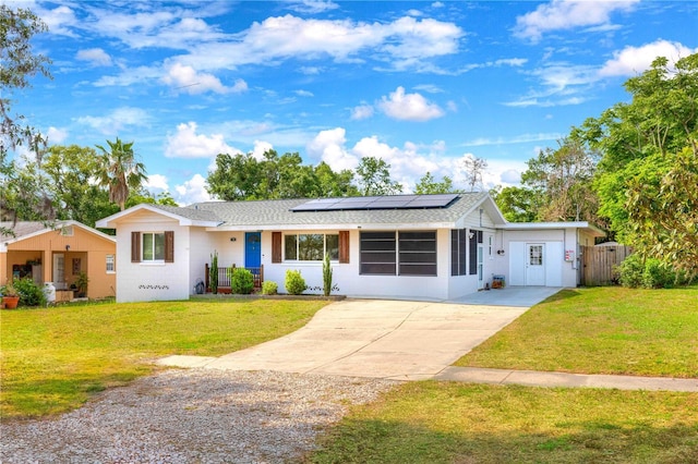 single story home featuring driveway, roof mounted solar panels, and roof with shingles