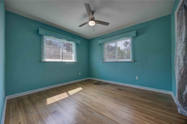 spare room featuring ceiling fan, wood finished floors, and baseboards