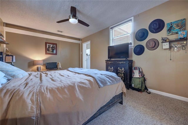 carpeted bedroom with a textured ceiling, baseboards, and a ceiling fan