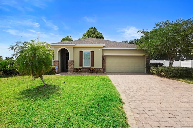 1480 Leitrim Loop, Apopka, FL 32703 - view of front of house with fence, an attached garage, stucco siding, a front lawn, and decorative driveway