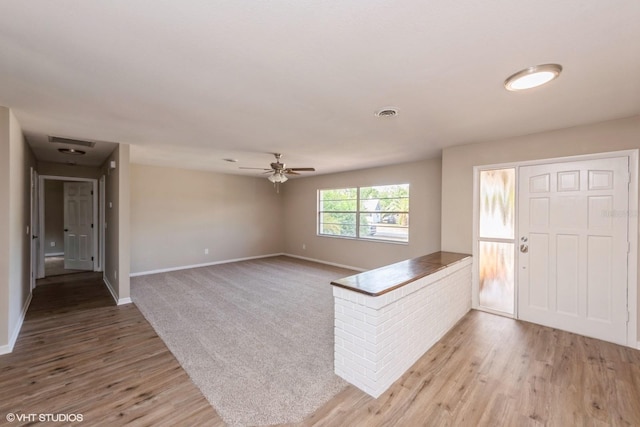 entryway featuring baseboards, light wood finished floors, ceiling fan, and visible vents