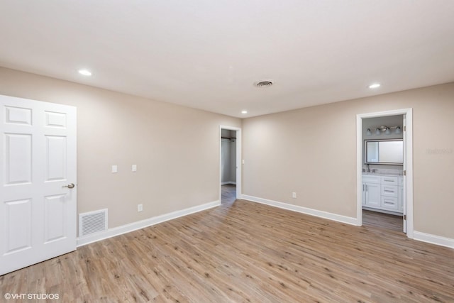 unfurnished room featuring light wood finished floors, visible vents, baseboards, and recessed lighting