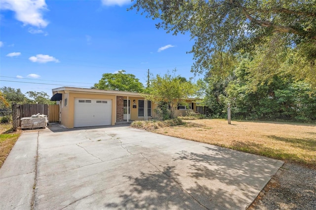 ranch-style home with concrete driveway, an attached garage, and stucco siding