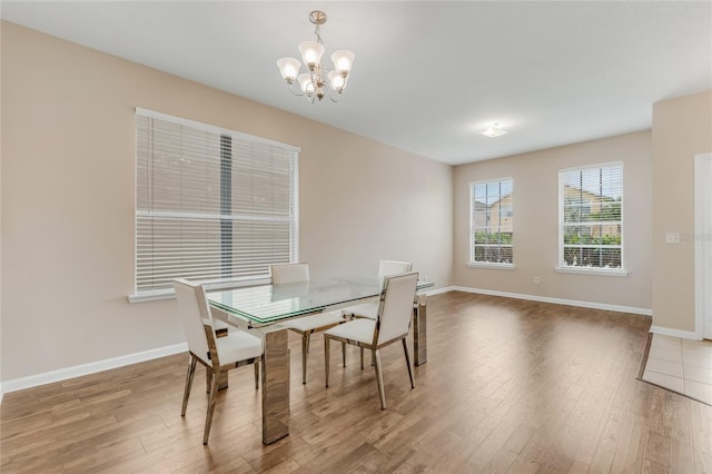 dining room featuring a chandelier, wood finished floors, and baseboards