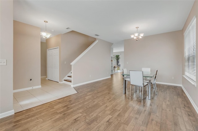 dining space with stairway, wood finished floors, a chandelier, and baseboards