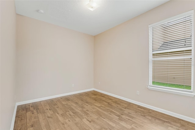 empty room with light wood-style flooring and baseboards
