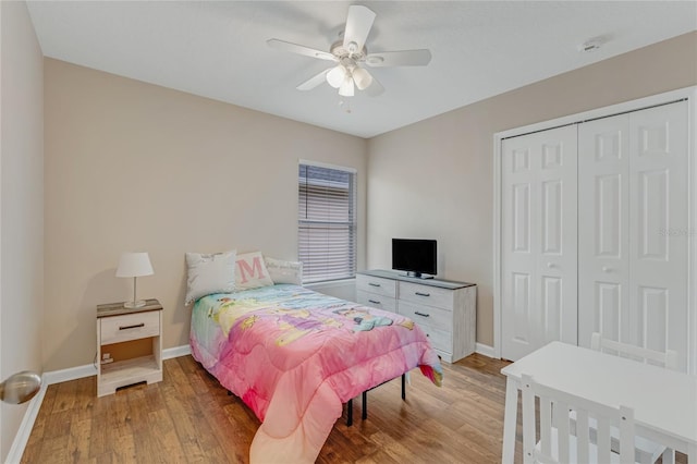 bedroom with a closet, light wood-type flooring, and baseboards