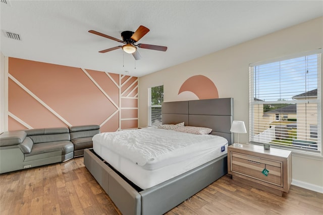 bedroom with wood finished floors, a ceiling fan, and baseboards