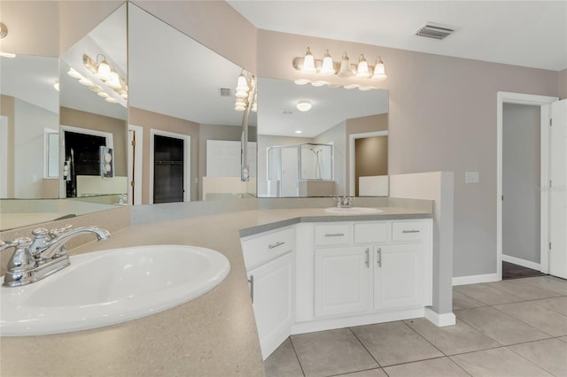 bathroom with tile patterned floors, a stall shower, baseboards, and vanity