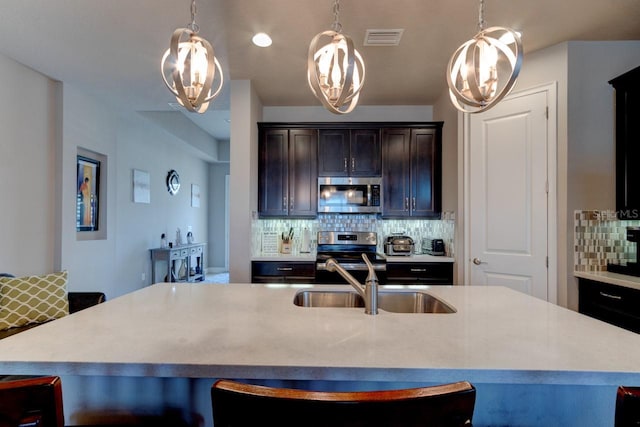 133 Azure Mist Way, Daytona Beach, FL 32124 - kitchen featuring stainless steel appliances, a sink, decorative backsplash, light countertops, and a kitchen bar