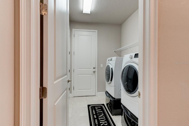 133 Azure Mist Way, Daytona Beach, FL 32124 - laundry room featuring independent washer and dryer, light tile patterned floors, and a textured ceiling
