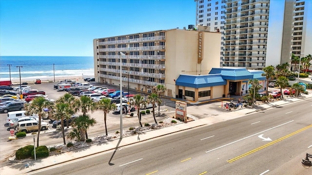 view of apartment building / complex featuring a water view and uncovered parking