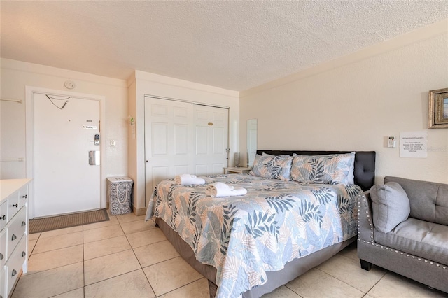 bedroom featuring light tile patterned floors, a textured ceiling, and a closet